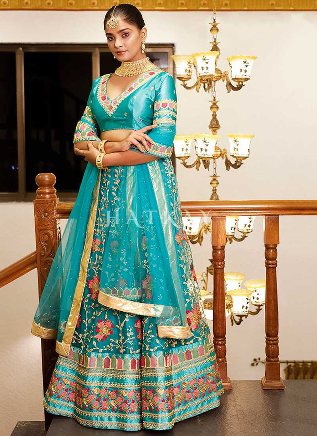 Teal green heavy embroidered wedding lehenga with long stylist choli